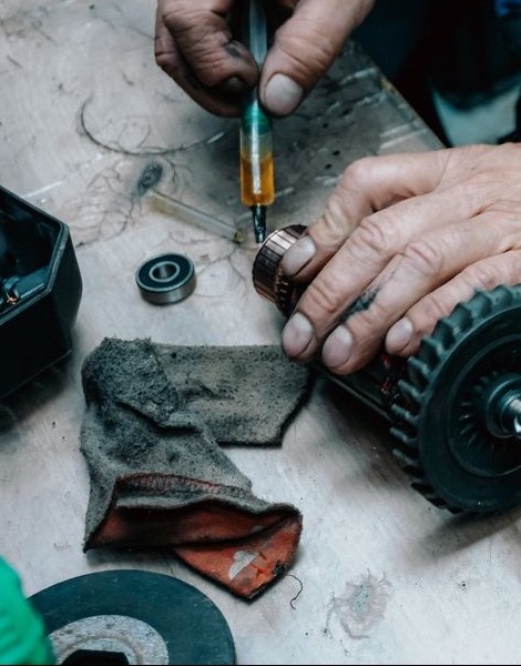 Hands repairing an electric motor on a workbench